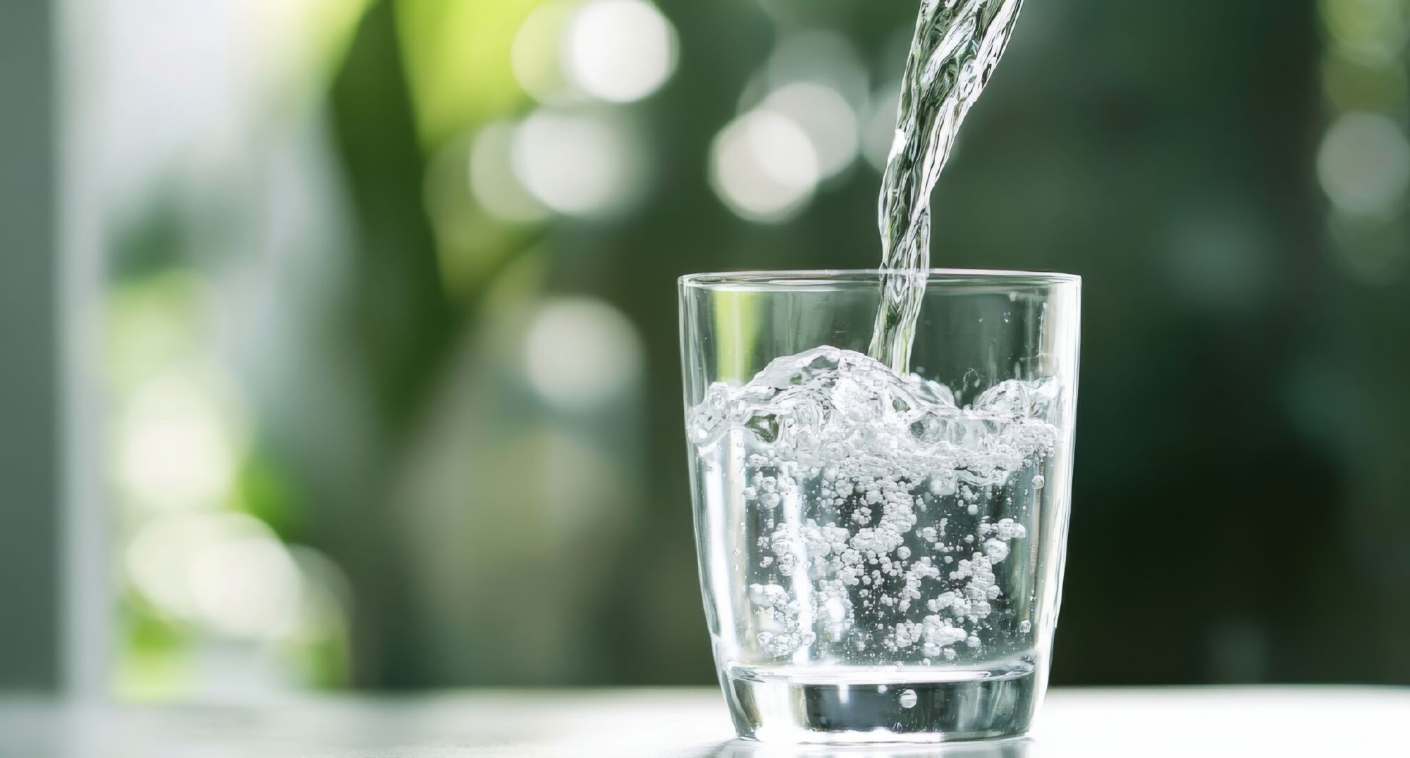 Pouring,Water,Into,A,Glass,Against,A,Green,Blurred,Background Baron & Budd Secures Long Term Structured PCB Settlements on Behalf of Arizona, Arkansas, Hawaii and Mississippi with Monsanto